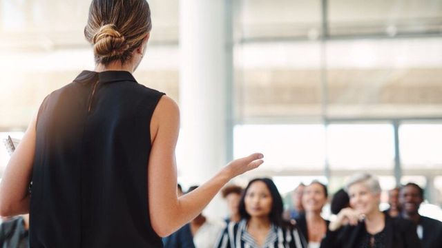 女性が座っているグループの前で話しています