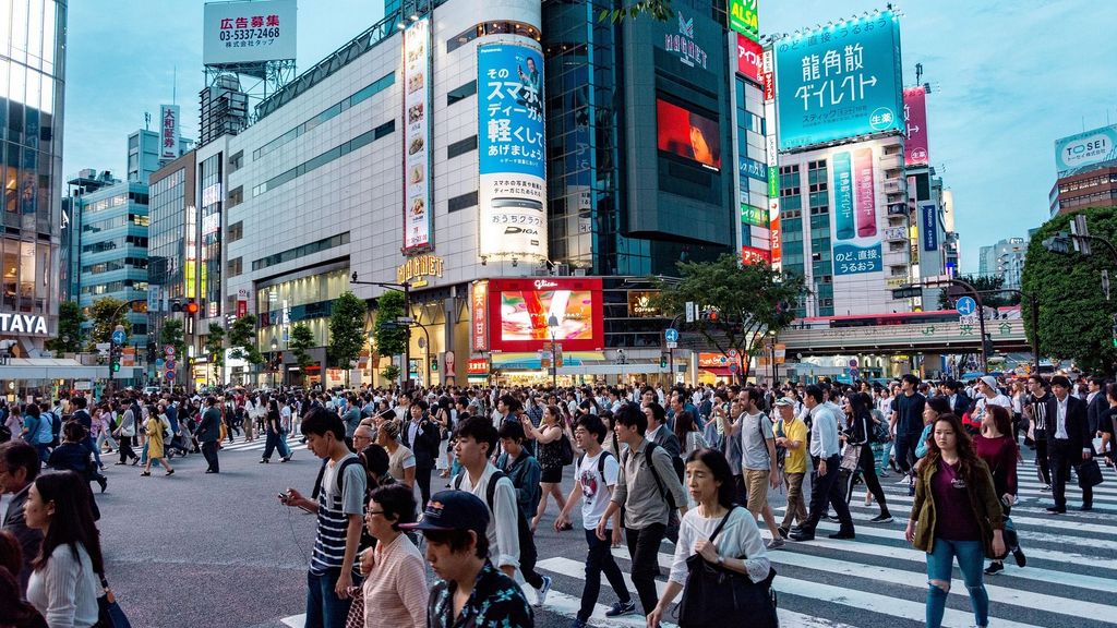 都市の大きな交差点を渡る群衆