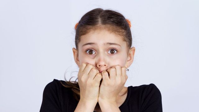 不安そうに爪をかむ少女