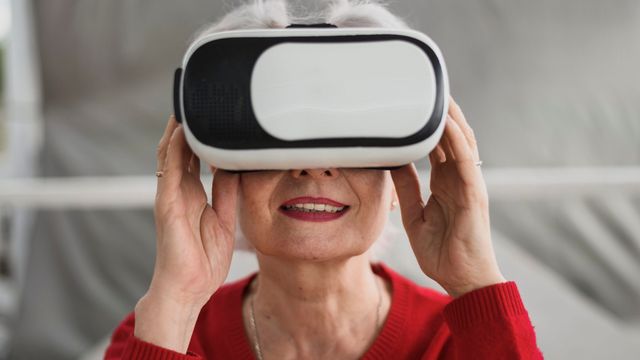 VRヘッドセットを装着してほほ笑む高齢女性