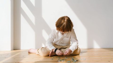 Un enfant assis seul dans une pièce lumineuse