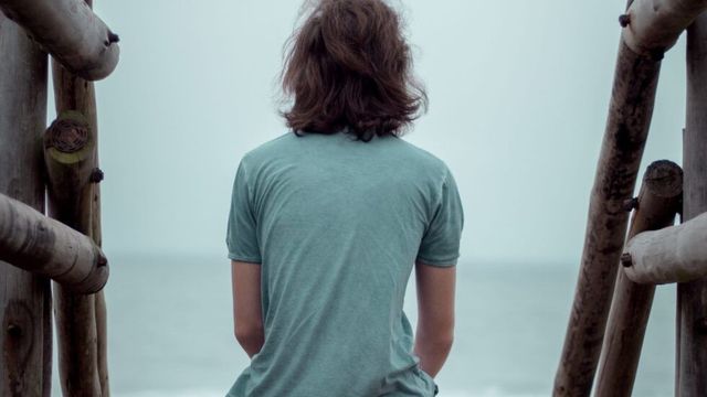 二つの手すりの間に孤独に座る人