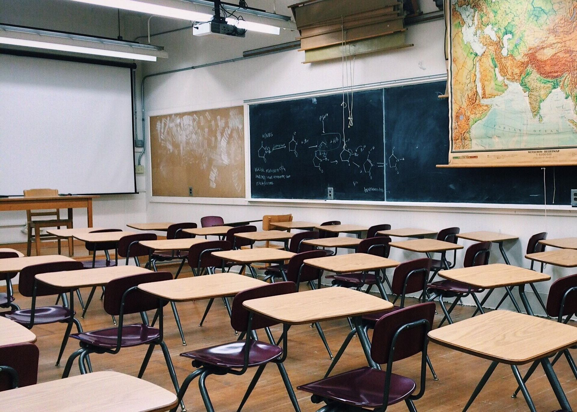 Leeres Klassenzimmer mit Tafeln und Weltkarte
