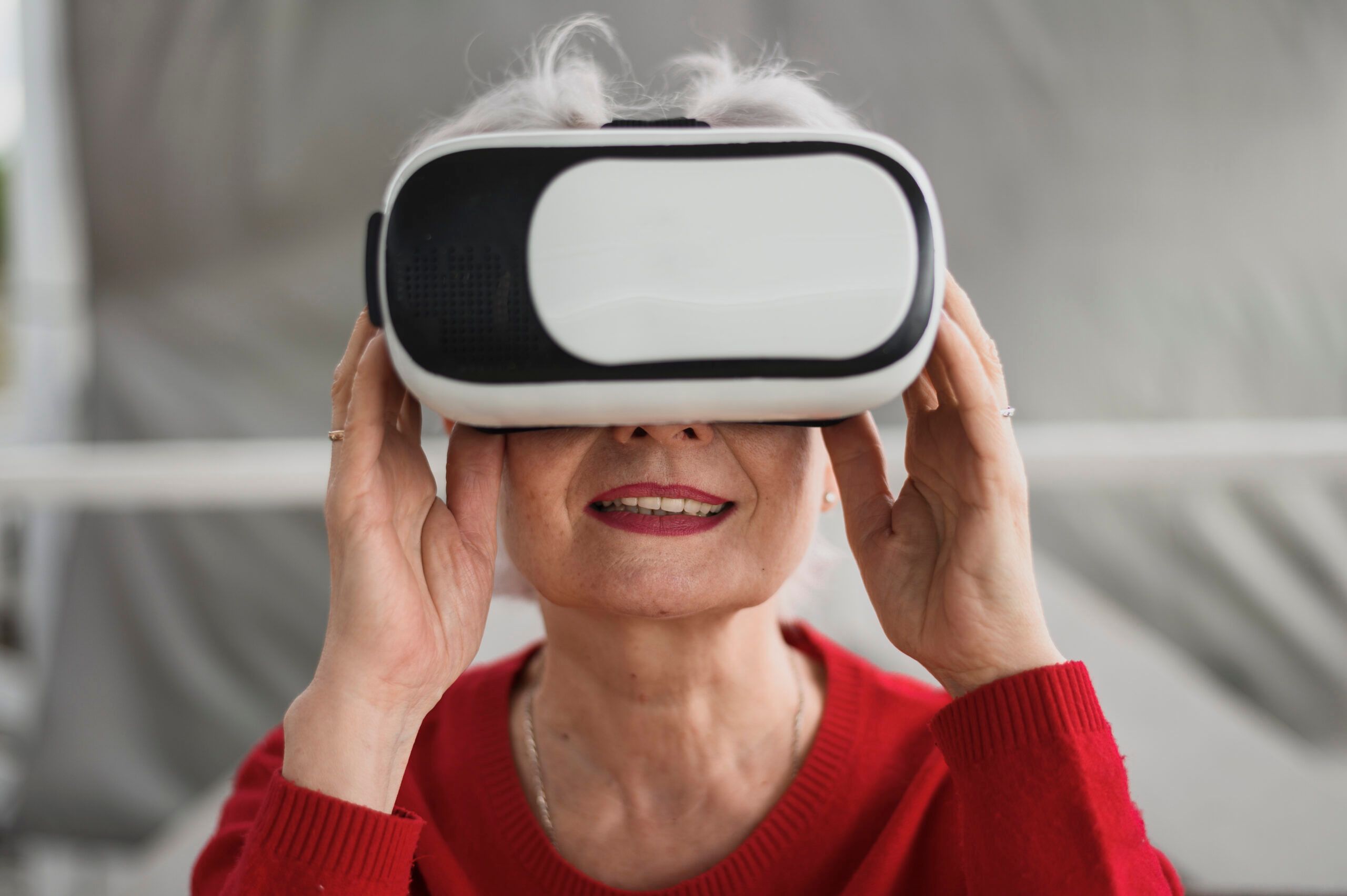 Une femme âgée sourit avec un casque de réalité virtuelle