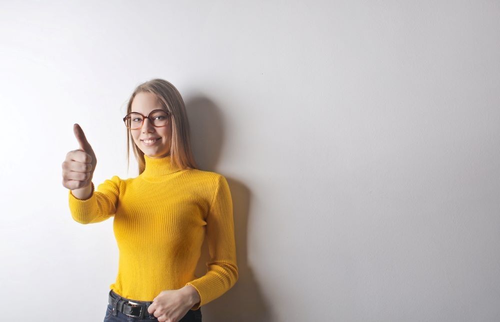 Una mujer sonriente levanta el pulgar