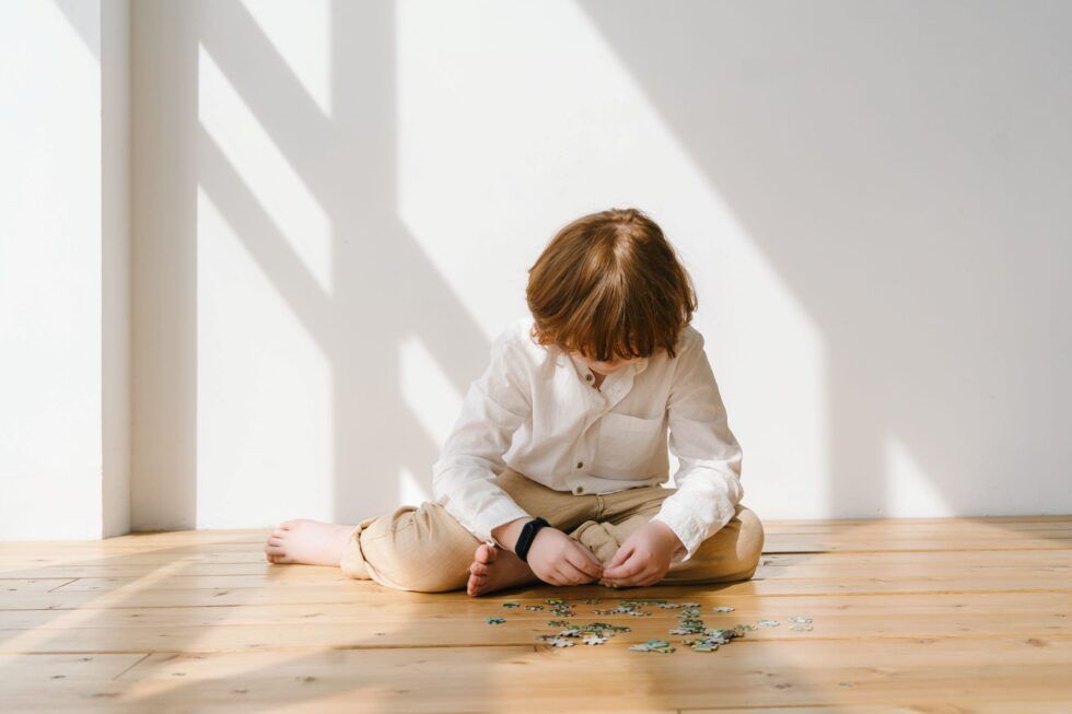 Un niño está sentado solo en una habitación luminosa