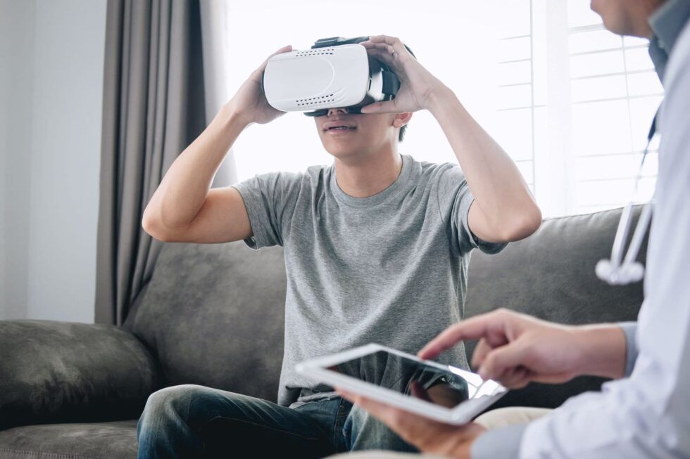 Una paciente utiliza un casco de realidad virtual con una terapeuta