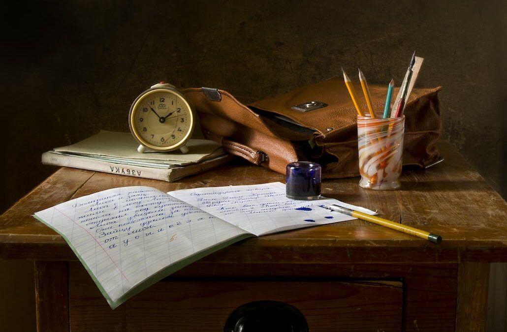 Pupitre escolar con cuaderno, pluma y material antiguo